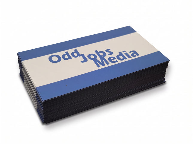 [photo] A stack of rectangular business card magnets with blue and white horizontal stripes and the text 'Odd Jobs Media' printed on a plain white background.
