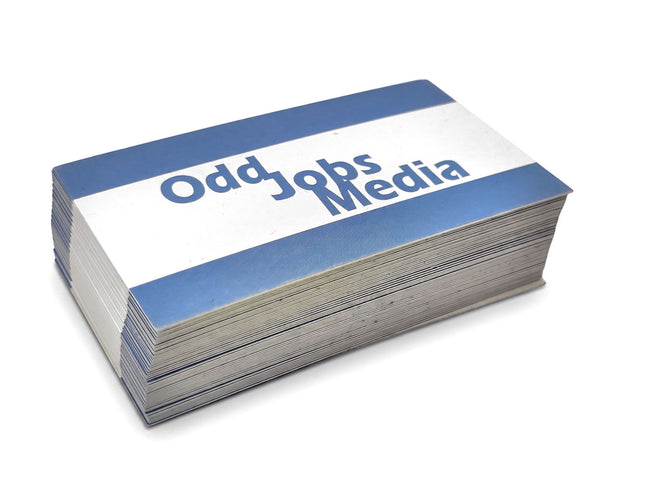 [photo] A stack of business cards with blue and white borders and the text 'Odd Jobs Media' printed on a pure white background.