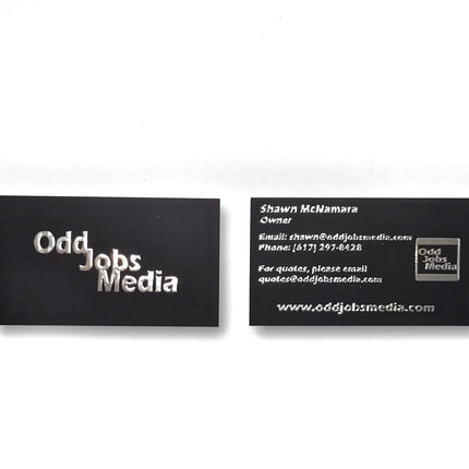 [photo] Two black rectangular business cards with white text, front and back, on a pure white background.