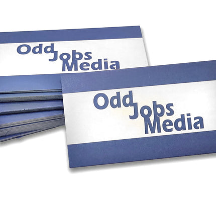 [photo] A stack of rectangular business cards with blue and white horizontal stripes and the text 'Odd Jobs Media' printed on a pure white background.