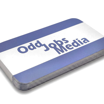 [photo] A stack of rounded corner business cards with a white and blue striped design, featuring the text 'Odd Jobs Media' in blue, photographed on a pure white background.