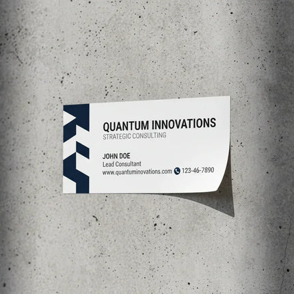 Custom business card sticker with company details adhered to a grey textured wall