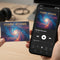 Plastic ID card with cosmic album artwork held next to smartphone showing same music track