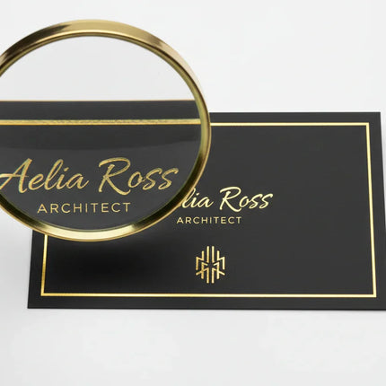 [AI] Black business card with raised metallic gold foil details and magnified design accent.