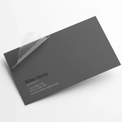 Black business card with clear lamination peeling off on white background