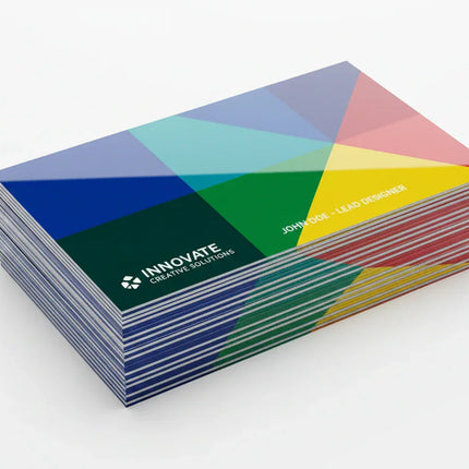 Glossy color business cards stacked on white background, custom printed design.