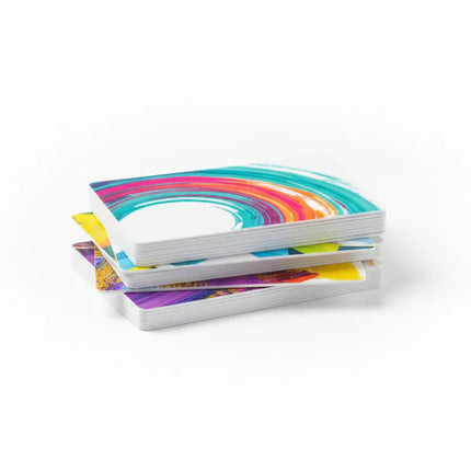 Stack of white PVC plastic business cards with vibrant color printing on white background