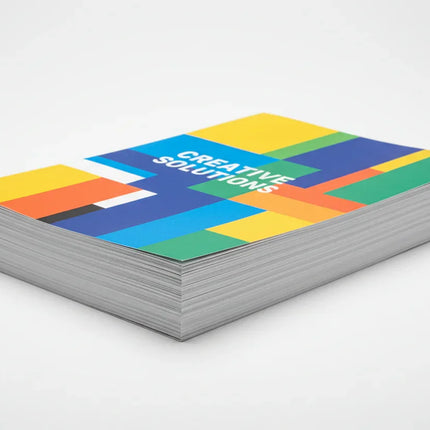 Stack of single-page color flyers with modern geometric design on white background