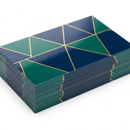Stack of custom printed business cards with geometric design, glossy coating on white background
