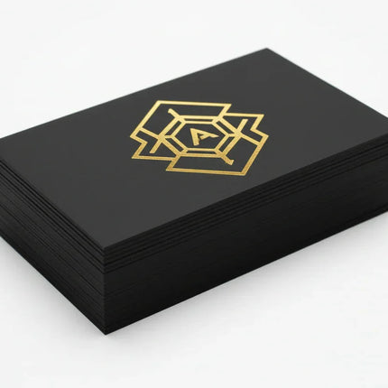 [AI] Stack of black business cards with metallic gold foil geometric design on thick stock