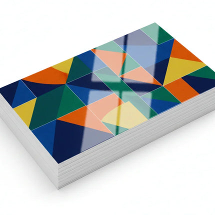 Stack of color-printed business cards with glossy aqueous coating on white background