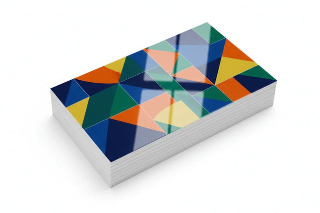 Stack of color-printed business cards with glossy aqueous coating on white background
