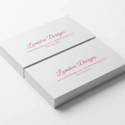 Stack of rectangular business cards with pink print on pearl paper, white background