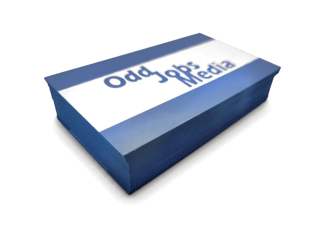 [photo] A rectangular stack of blue and white business cards with the words 'Odd Jobs Media' printed on a pure white background.