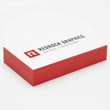 Stack of custom red edge business cards with white front and PMS 186 red sides on white background